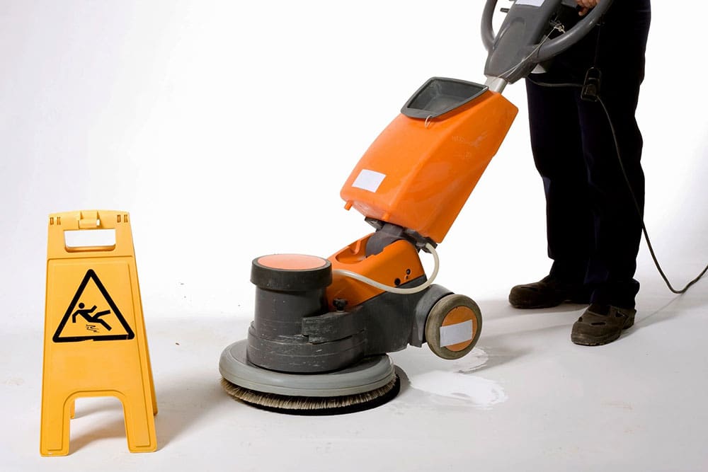 A man is using a floor polisher.