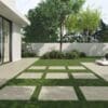 backyard of a house with tiles on the grass